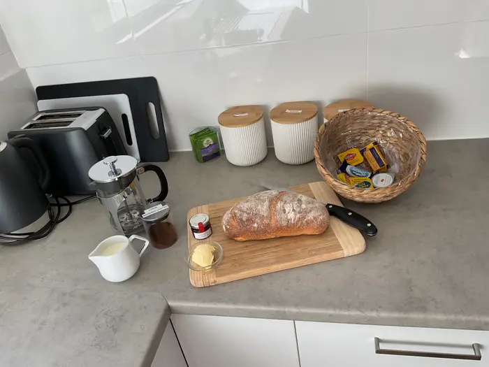 Coffee, bread and spreads on the kitchen bench