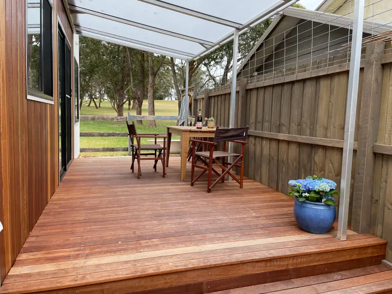 Covered deck with table and chairs looking over the paddock